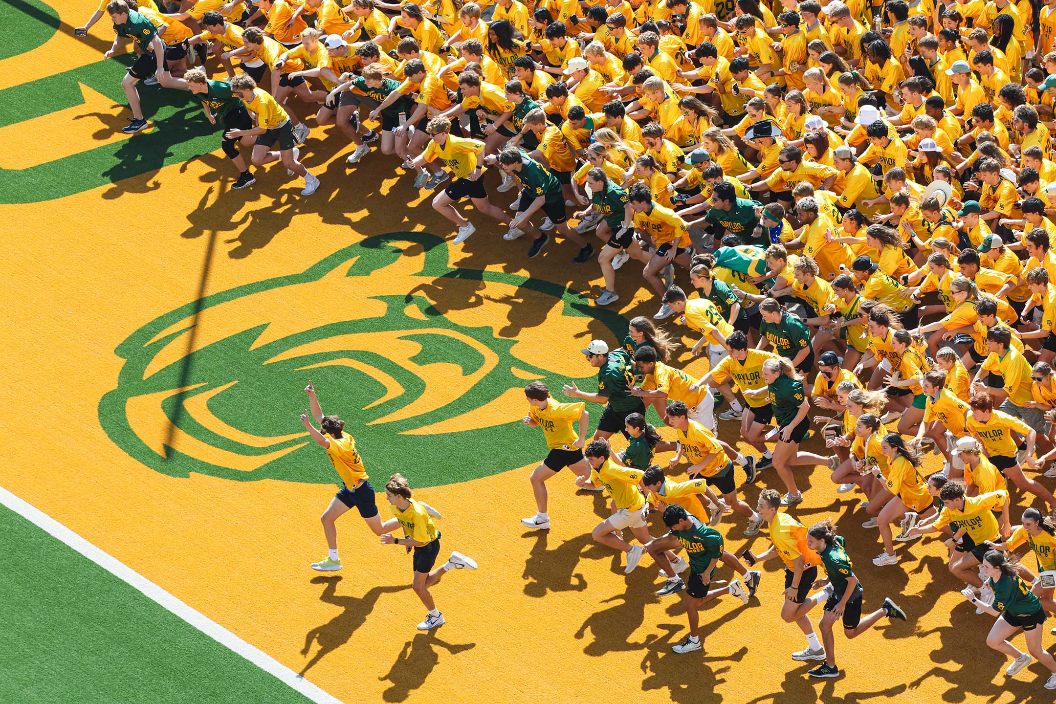 Students running in The Baylor Line during a football game