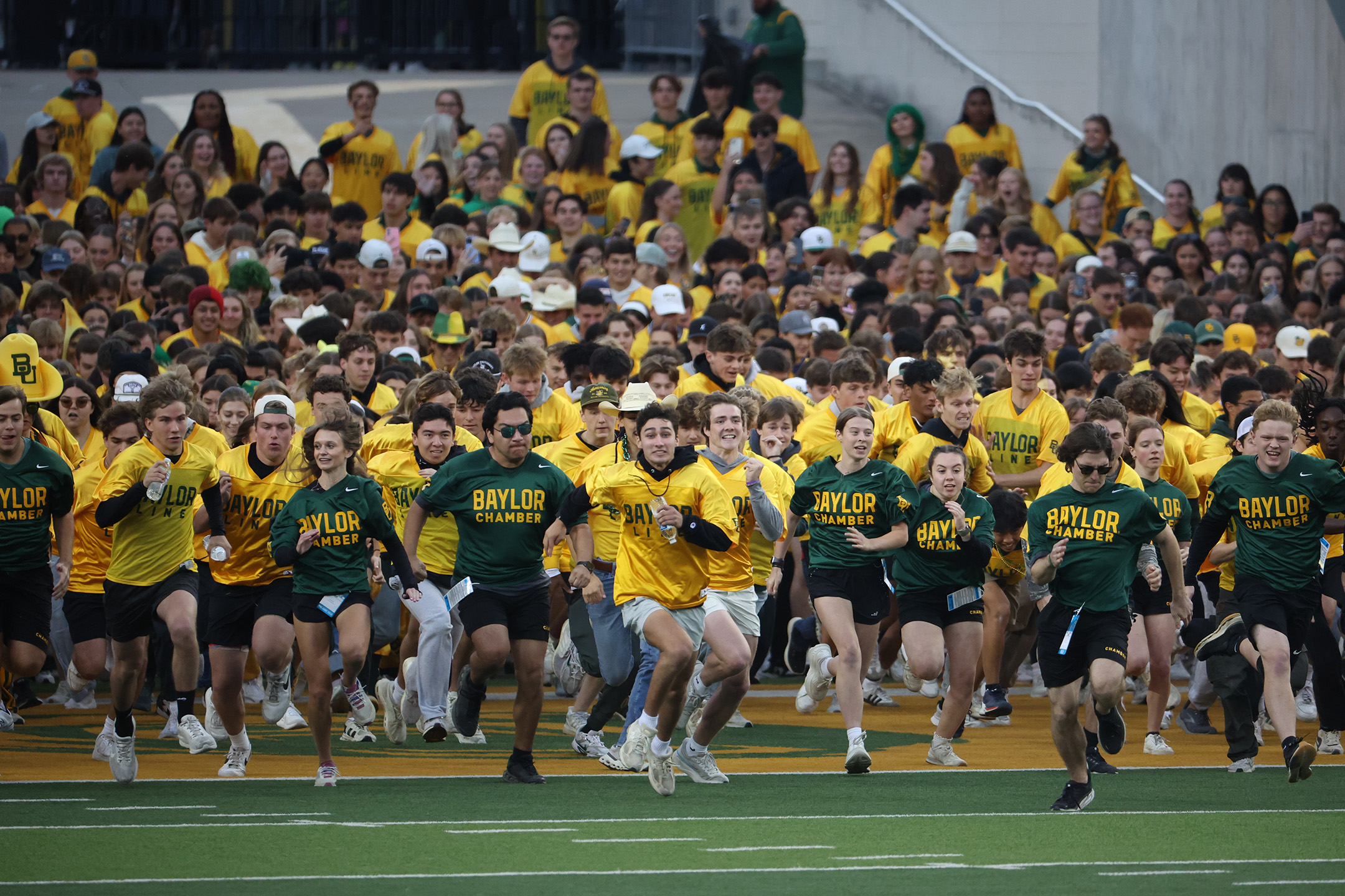 Students running in The Baylor Line during a football game